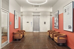 A lobby with a reception desk, a waiting area with chairs, and a staircase leading to an upper floor. - VCAY - Bridge View 5BR-5BA  (New Orleans)