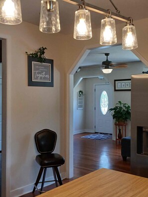 Un intérieur moderne comprenant un coin repas, une chaise noire, une table en bois et un ventilateur de plafond.