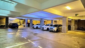 Eine Parkgarage mit mehreren Autos unter einer Decke mit Dachfenstern.