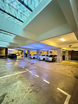 A parking garage with multiple cars parked under a ceiling with skylights. - Elegant Studio in kiambur road,fast Wifi & Free Parking (Nairobi)