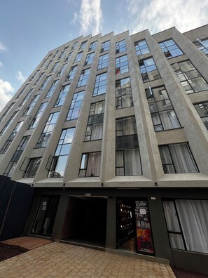 A multi-story building with a modern architectural style, featuring a series of windows and balconies. - Elegant Studio in kiambur road,fast Wifi & Free Parking (Nairobi)