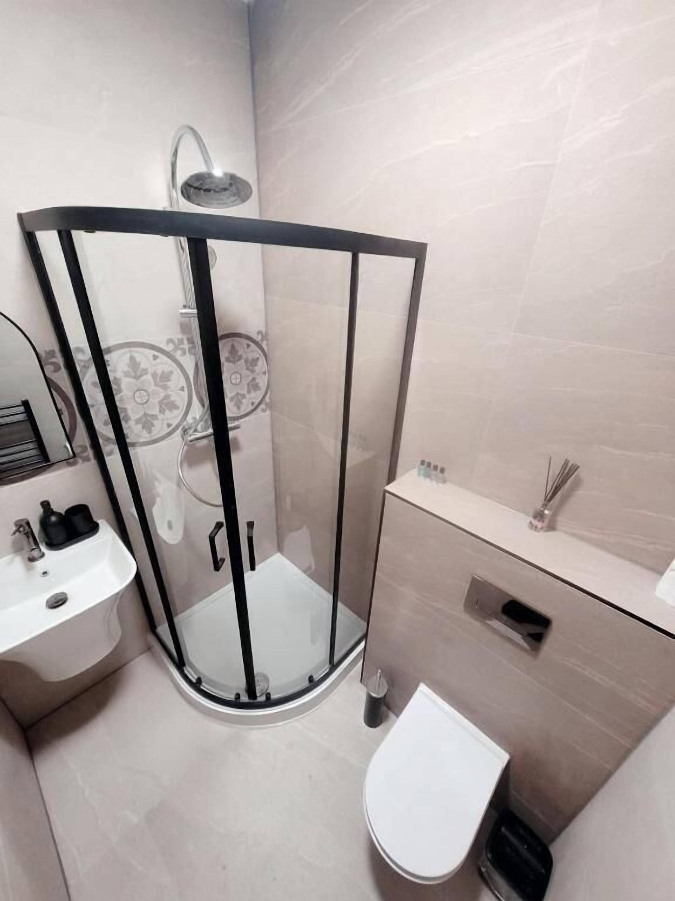 Ein modernes Badezimmer mit einer Duschkabine, einer Toilette und einem Waschbecken.