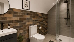 Ein modernes Badezimmer mit Toilette, Waschbecken und Dusche.