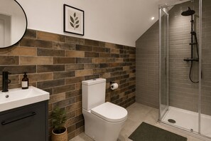 Ein modernes Badezimmer mit Toilette, Waschbecken und Dusche.