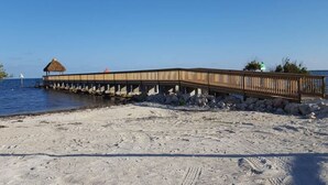 A wooden pier extending into the water with a thatched-roof structure at one end. - Key Largo Resort 2bd/2bth Ocean Views (Tavernier)