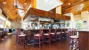 A bar area with wooden ceiling, bar stools, and a counter with various items. - Key Largo Resort 2bd/2bth Ocean Views (Tavernier)