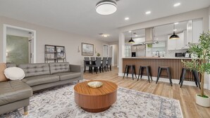 Un salon moderne avec un canapé, une table basse et un tapis à motifs.