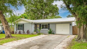 Une maison de plain-pied avec un garage, une allée et une pelouse.