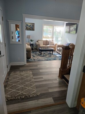 A living room with a sofa, coffee table, and a patterned rug. - Nice 5-bedroom renovated farmhouse,  with A-C, 1.6miles/5 min to beaches (South Haven)