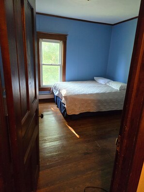 A bedroom with a single bed, a window, and wooden flooring. - Nice 5-bedroom renovated farmhouse,  with A-C, 1.6miles/5 min to beaches (South Haven)