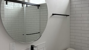 A bathroom with a white sink, a mirror, and a toilet.