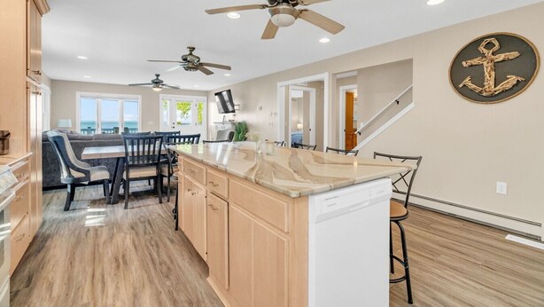 A spacious kitchen with a central island, two ceiling fans, and a large window providing a view.