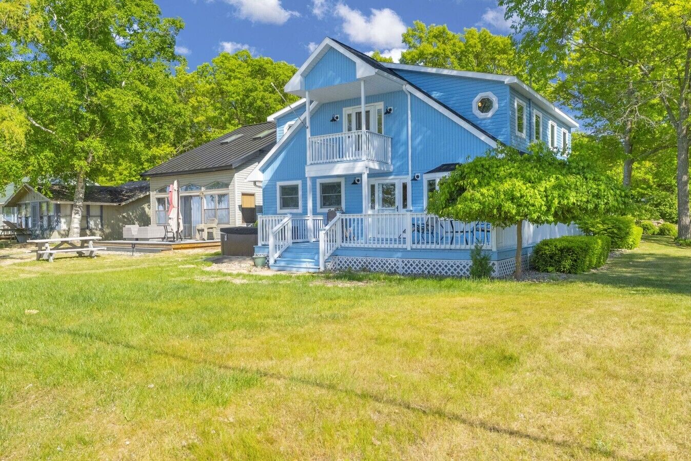A two-story house with a porch and a small deck.