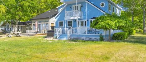 A two-story house with a porch and a small deck.