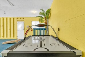 Shuffleboard-pöytä huoneessa, jonka seinät ovat keltaiset ja katto valkoinen.