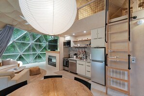 Una cocina moderna con comedor, ventanas amplias y un entrepiso con vistas.