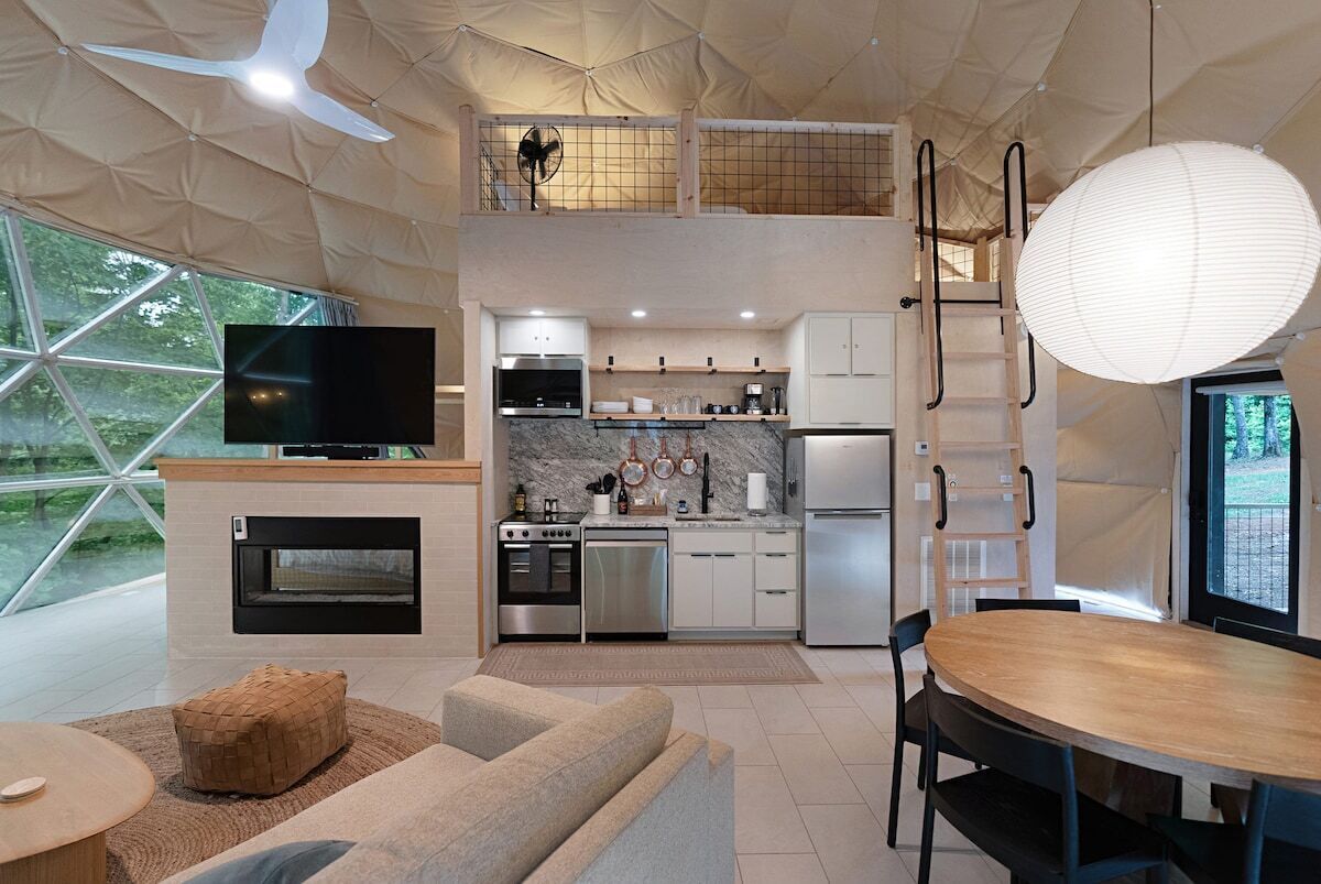 Una cocina moderna con televisor, horno y comedor.