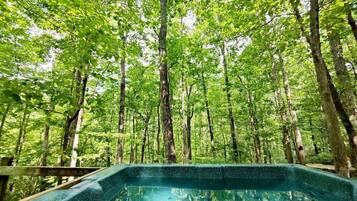 A hot tub surrounded by a forested area.