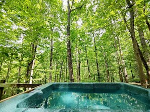 A hot tub surrounded by a forested area.