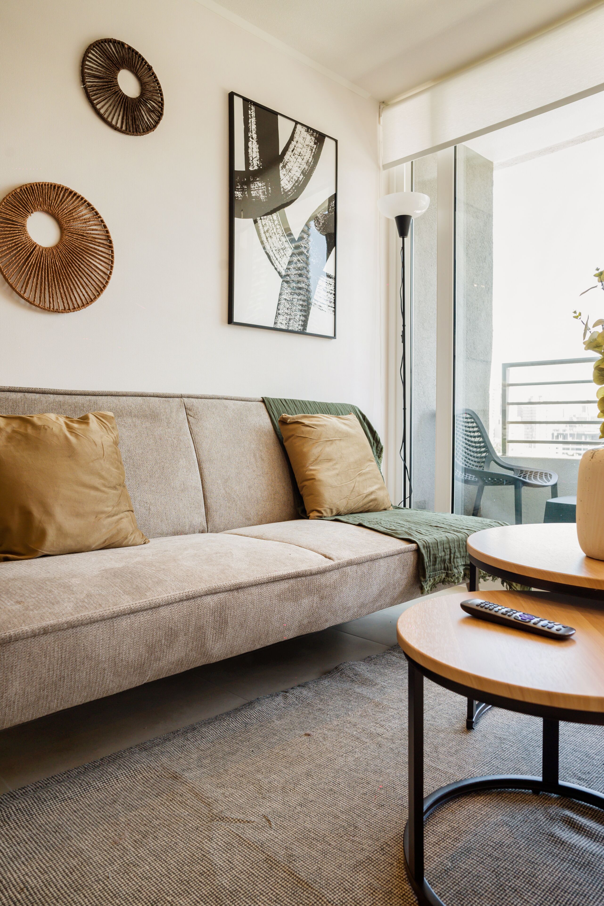 En moderne stue med sofa, sofabord og kunst på væggen.