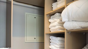 Un armario amplio con repisas para toallas dobladas y una puerta con cerradura.