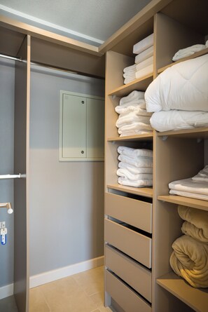 Ein begehbarer Kleiderschrank mit Regalen für gefaltete Handtücher und einer Tür mit Schloss.