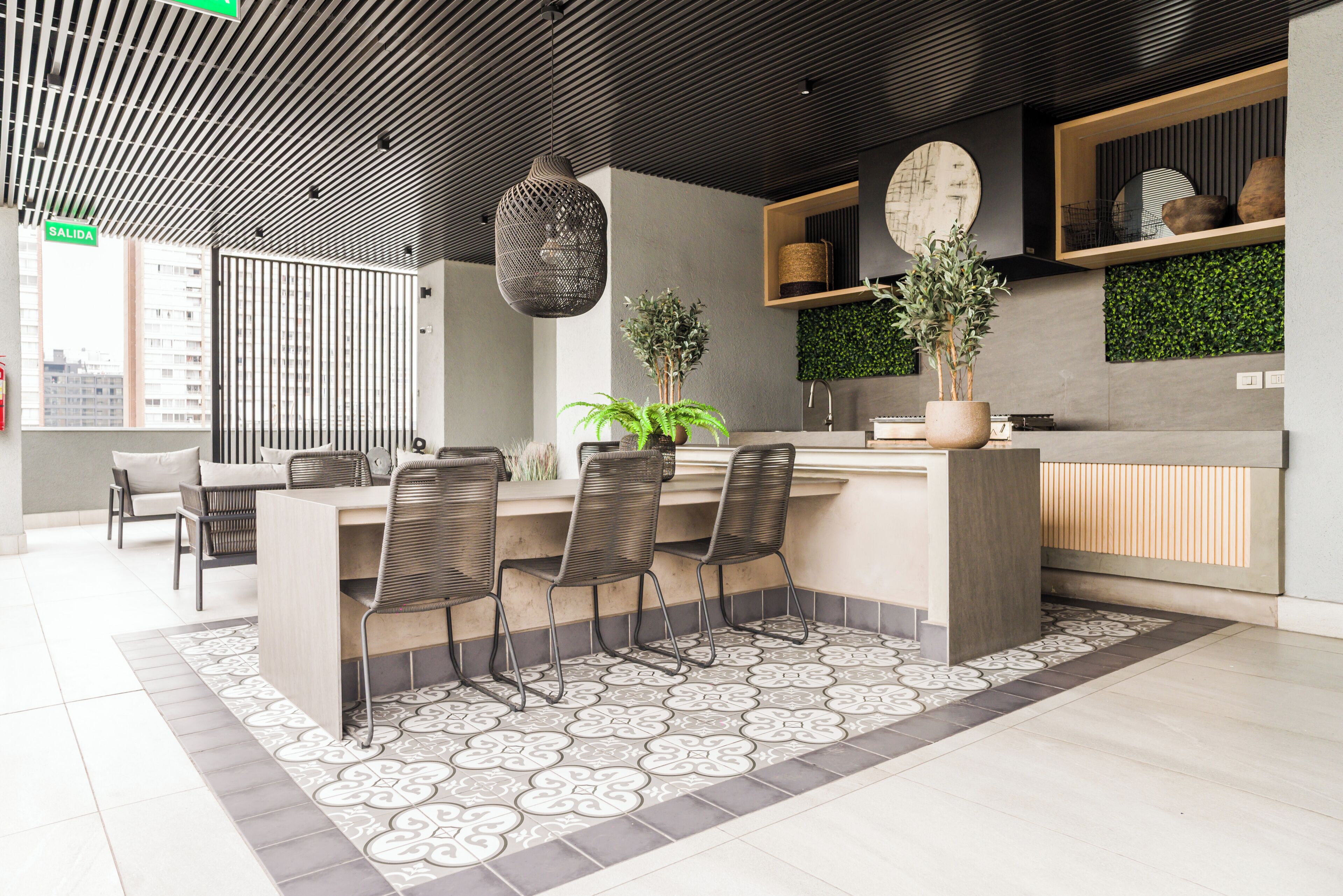 A modern kitchen with a central island, bar stools, and a potted plant.