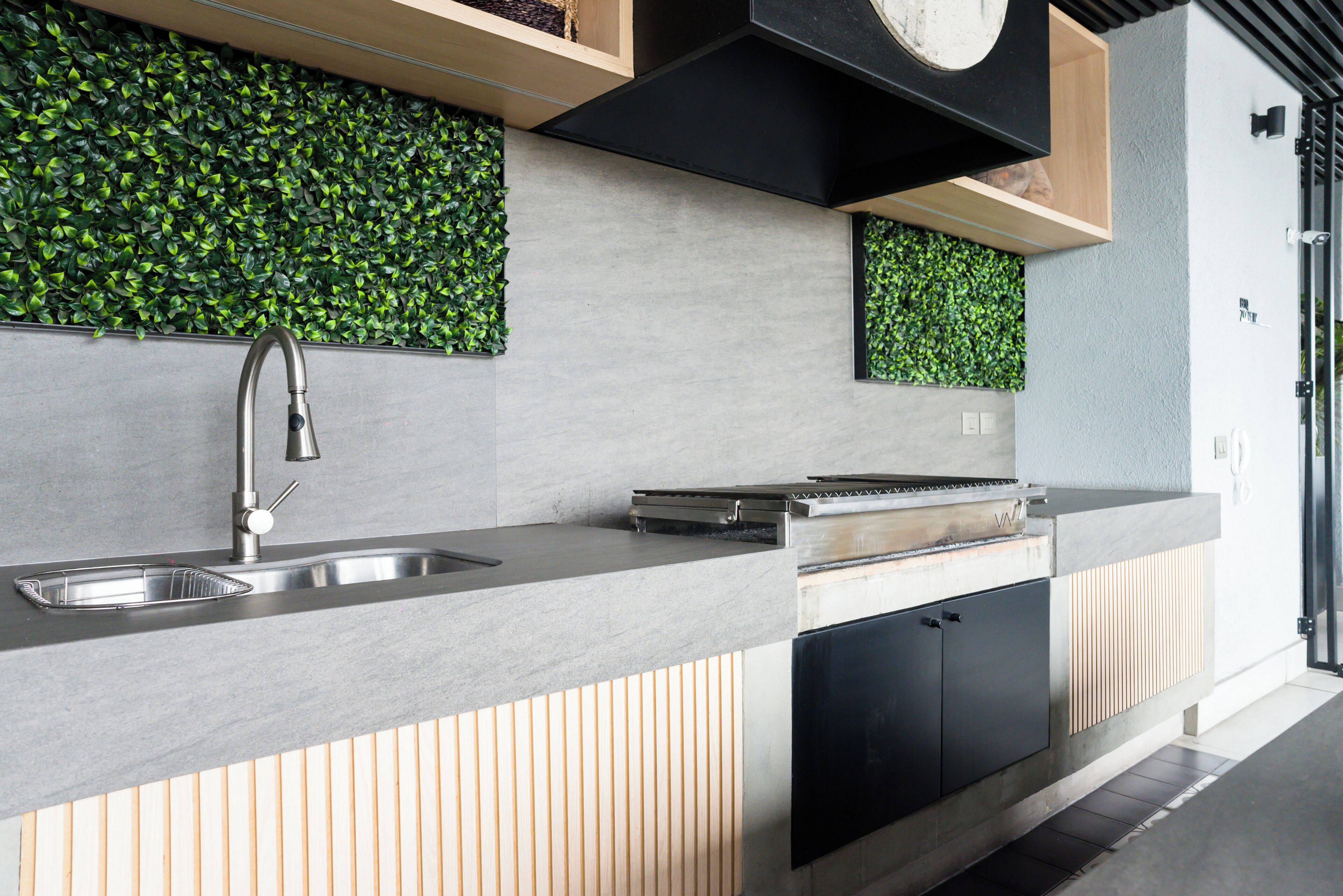 A modern kitchen with a built-in sink, a stove, and a black cabinet.