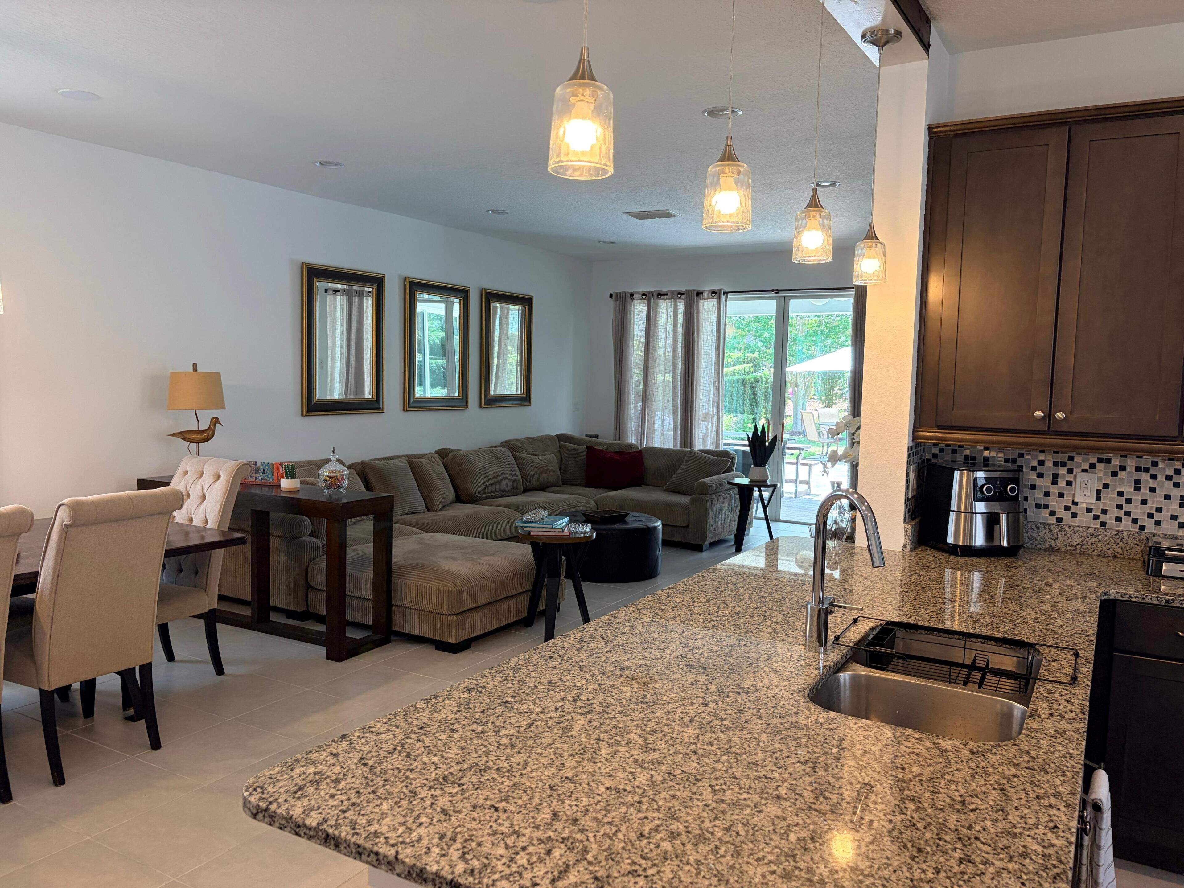 A modern kitchen with granite countertops, a built-in sink, and stainless steel appliances.