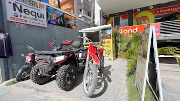 Una motocicleta estacionada frente a un edificio con un cartel anunciando una farmacia.