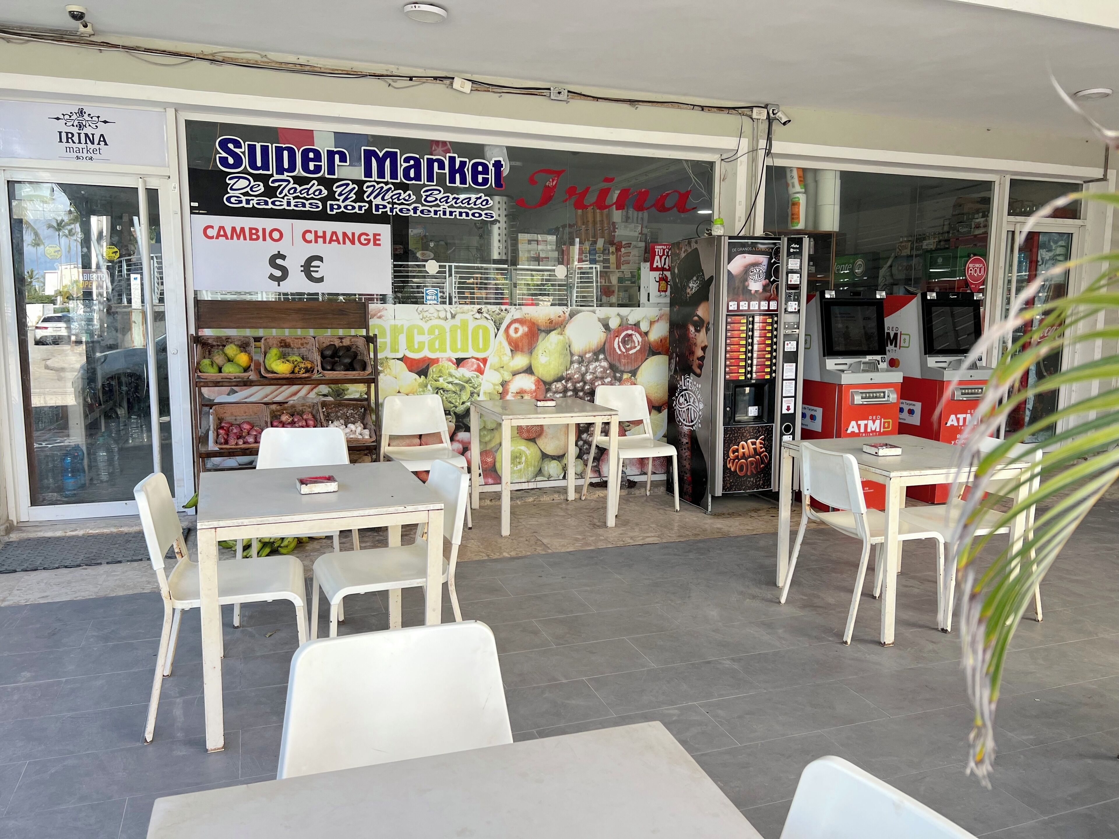 A Super Market with a 'CAMBIO CHANGE' sign, a 'Mercado' sign, and a 'Cafe World' vending machine.