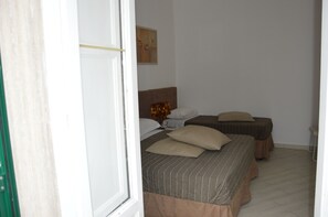 Ein Hotelzimmer mit zwei Betten, einem Bild an der Wand und Holzboden.