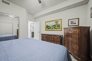 A bedroom with two beds, a dresser, a door leading to another room, and a painting on the wall. - NEW!! 2-bedroom Condo in Tranquil Chandler with cool AC (Chandler)