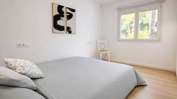 Ein Schlafzimmer mit einem Bett, einem Sessel und Bildern an der Wand.