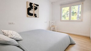 Ein Schlafzimmer mit einem Bett, einem Sessel und Bildern an der Wand.