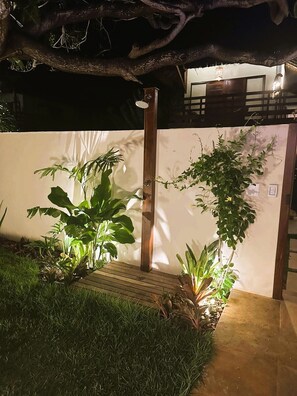 A garden area with a wooden bench, a small wooden platform, and various plants. - Deluxe Villa Luz Do Mar, rooftop Jacuzzi, sea view (Jijoca de Jericoacoara)