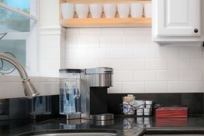 Eine Küche mit Kaffeemaschine, Wasserspender und Gewürzregal.