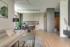 Un salon moderne avec un canapé, une table basse et un coin repas.