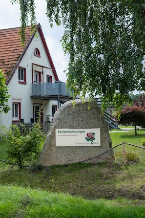 A stone sign with a logo and text indicating a property named 'Ferienwohnungen' with a website address. - Vacation Rental Near Sababurg Zoo: Sleeping Beauty Room (Hofgeismar)
