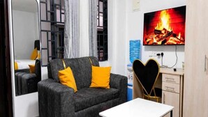 Ein modernes Wohnzimmer mit einer Couch, einem Couchtisch, einem Fernseher und einem Spiegel.