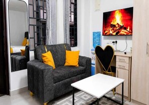 Ein modernes Wohnzimmer mit einer Couch, einem Couchtisch, einem Fernseher und einem Spiegel.