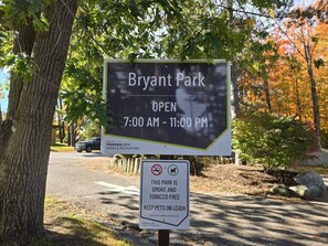 A sign for Bryant Park indicating it is open from 7:00 AM to 11:00 PM.