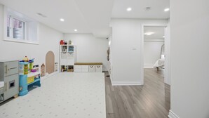 Una habitación amplia con techo alto, ventana grande y suelo de madera.