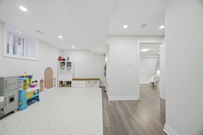 A spacious room with a high ceiling, a large window, and a wooden floor. - Upscale 5BR Home + 2 Offices + Kids Playroom + Ideal for large families (Mississauga)