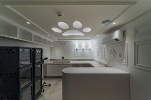 A modern kitchen with a central island, pendant lighting, and a built-in stove. - Gran Valley - GAV Hotéis e Resorts (Gramado)