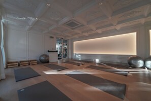 A spacious room with exercise mats, wooden benches, and exercise balls.