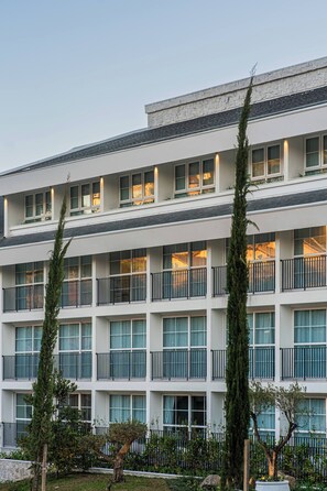 A multi-story hotel with balconies and large windows.