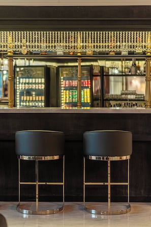 A bar area with two stools and a decorative overhead.