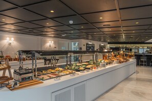 A buffet setup with various food items and a grill station. - Gran Valley - GAV Hotéis e Resorts (Gramado)