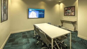 A conference room with a long table, chairs, a flat-screen TV, and artwork on the walls. - Landing | Stunning 1BD, Gym, Yoga Studio (Omaha)
